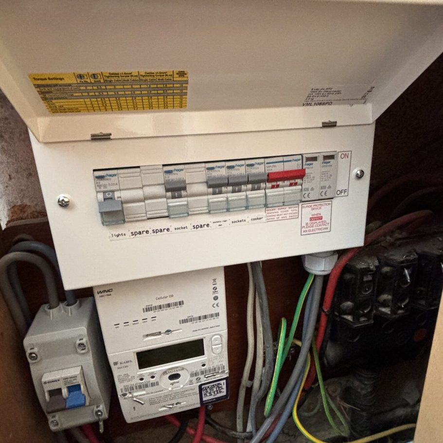 Electrical distribution board with wires and a digital meter inside a utility cabinet.